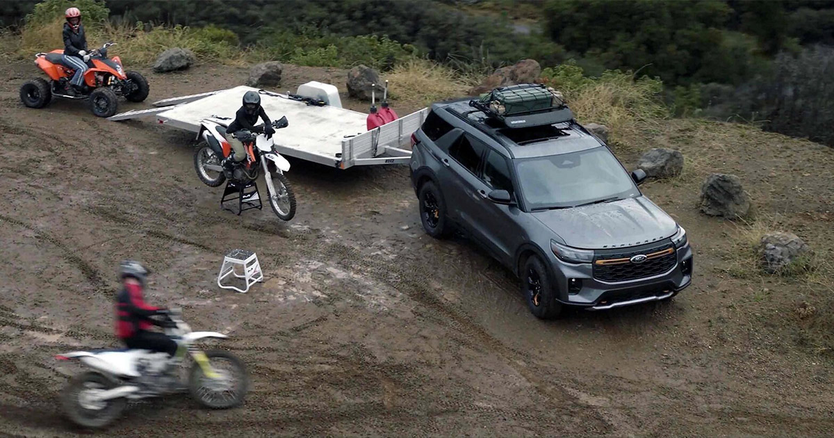 2025 Explorer outdoors with motorcycles and ATVs.