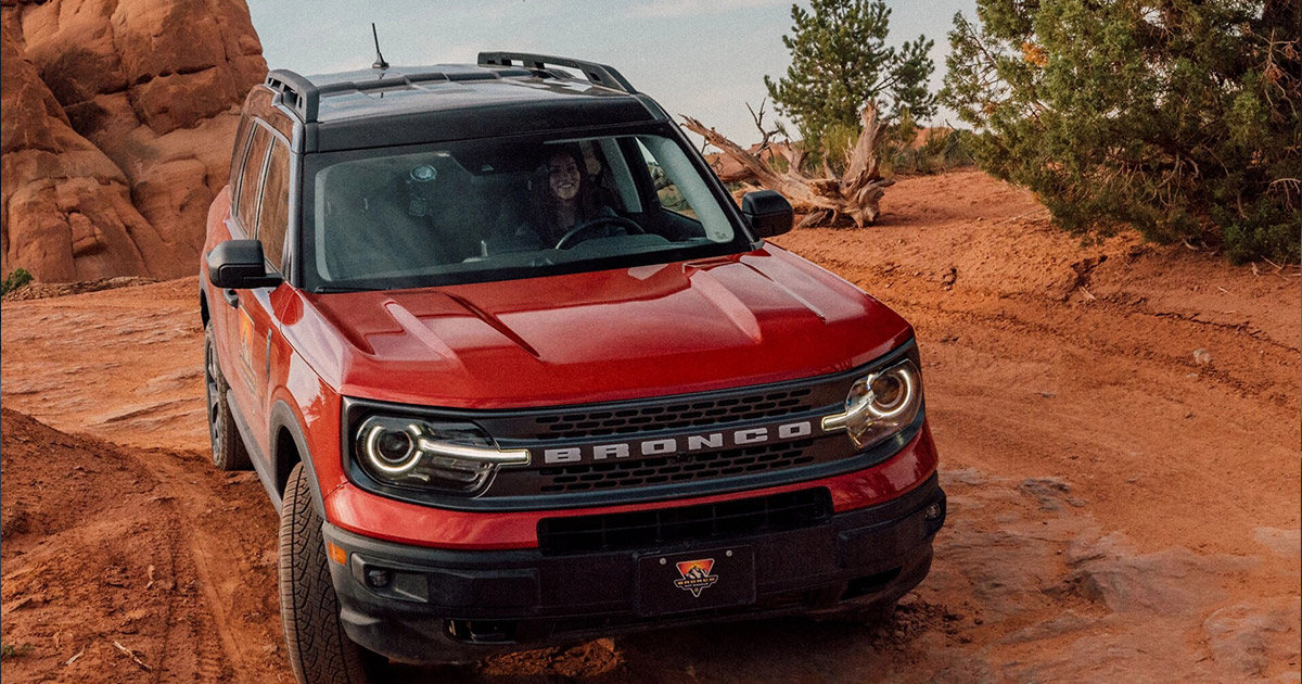 2025 red Ford Bronco traveling through a canyon road.
