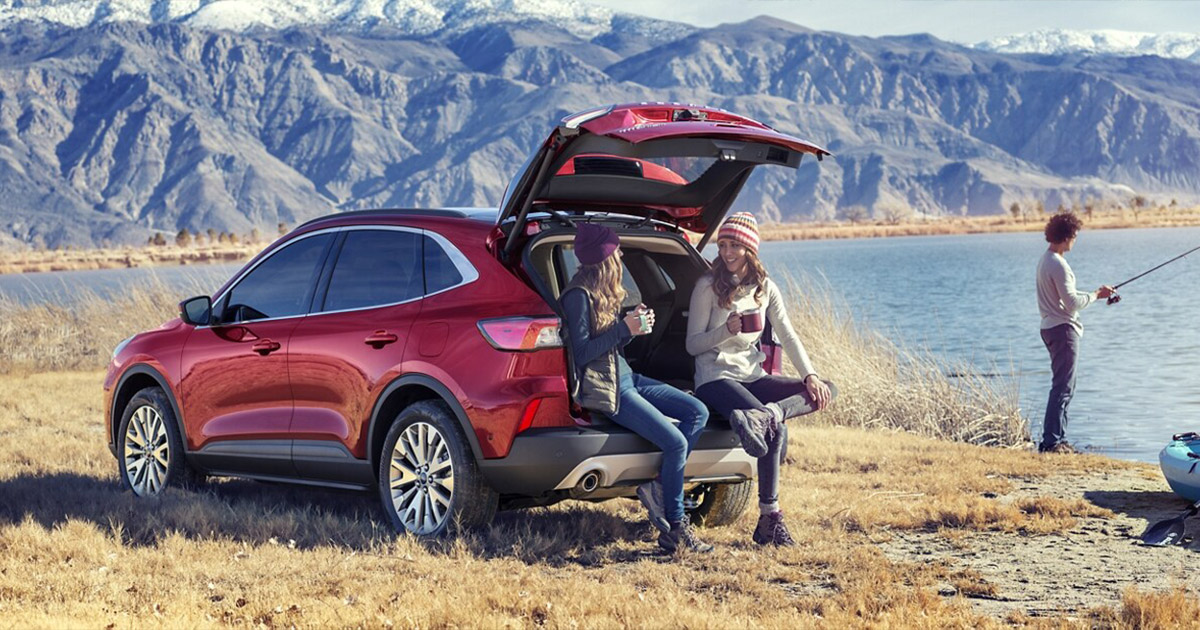 2025 Ford Escape with friends talking and fishing outside in a mountain scape.