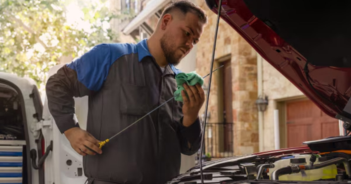 Man checking oil on a Ford vehicle.