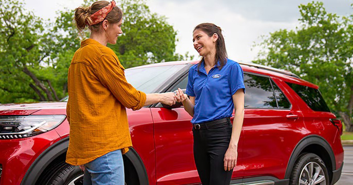 Woman talking to a female Ford service technician.
