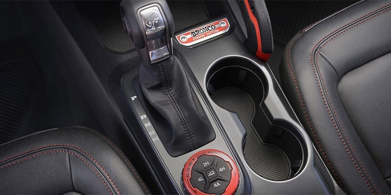 A close up look at the clutch and cup holders of a ford bronco