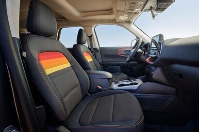 The front interior of a ford bronco sport with yellow,red,orange stripes