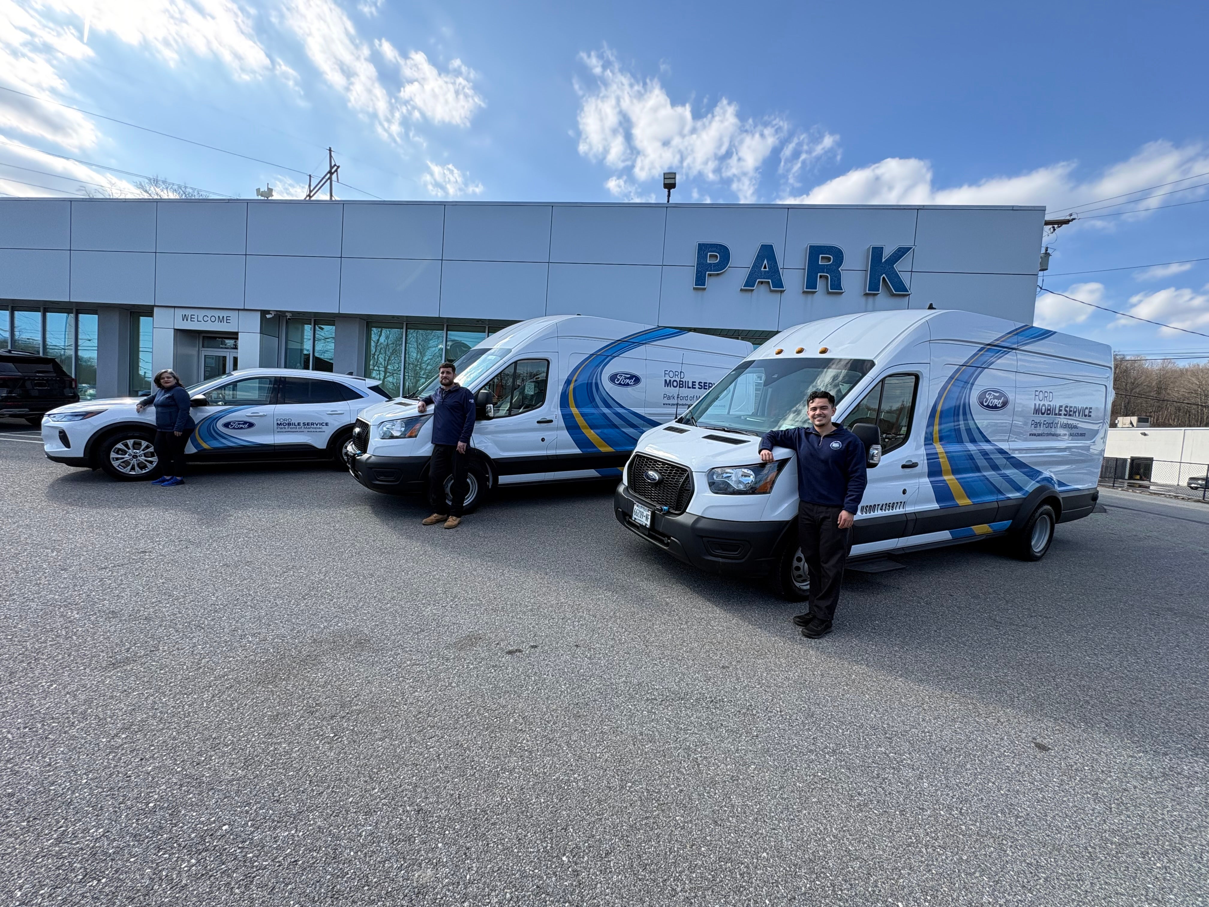 Two men standing beside a white Ford Mobile Service van with blue and yellow accents.