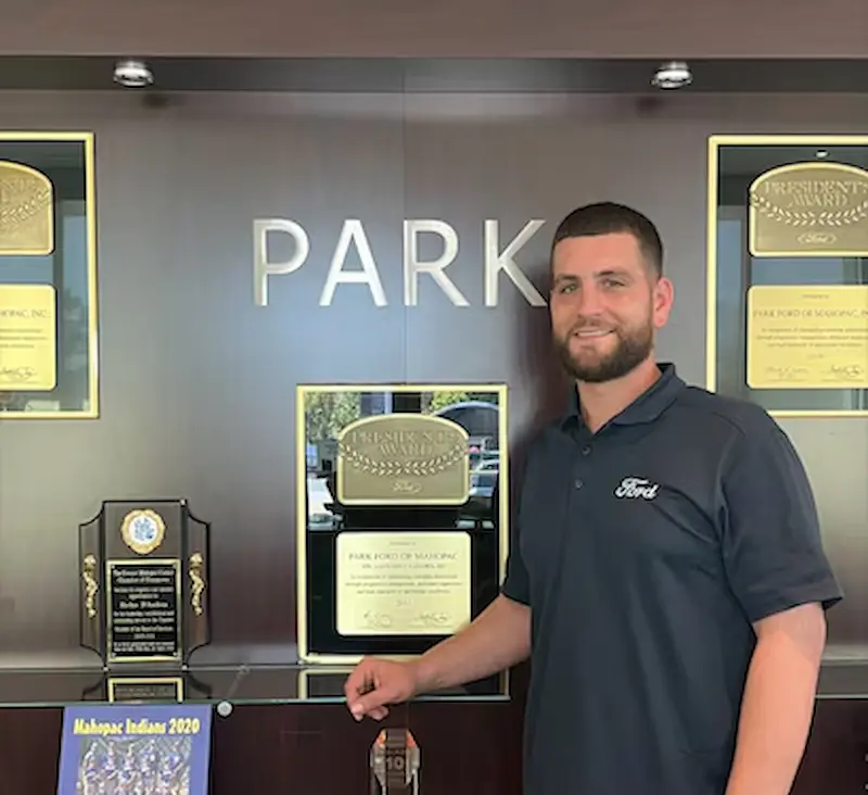A Park Ford Of Mahopac employee in front of awards won