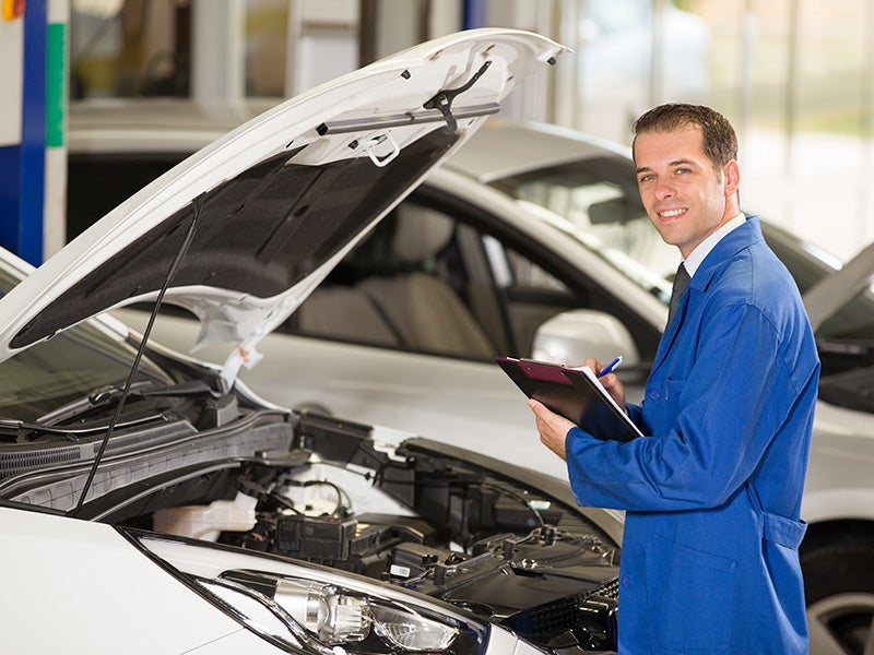 A Ford service Technician working on a vehicle brakes