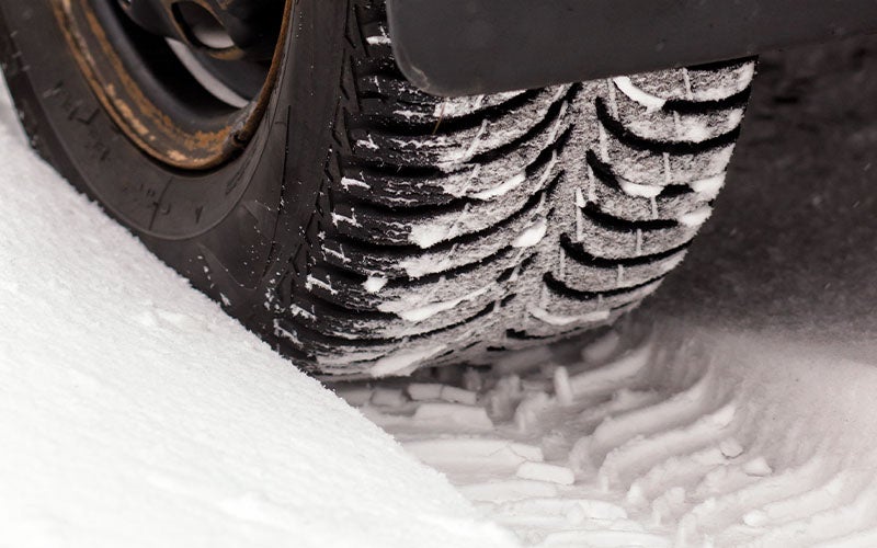 Close-up of a vehicle tire on snow-covered ground